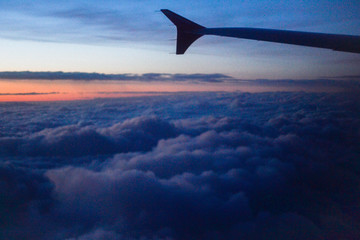 Naklejka na ściany i meble wing of airplane flying above clouds