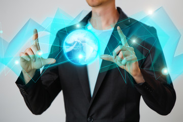 Businessman holding the glowing hologram digital globe. Concepr of business and innovation