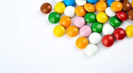 colorful candy on white background. Rainbow sprinkles for topping ice cream and cake. Small candies in colored chocolate glaze.