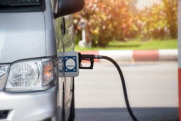 Fill the van with fuel. The van is filled with diesel at a gas station by gas station pump.
