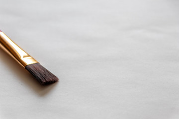 Sauberer Pinsel mit Goldfassung wartet auf den Künstler und hilft ihm bei seinem Gemälde