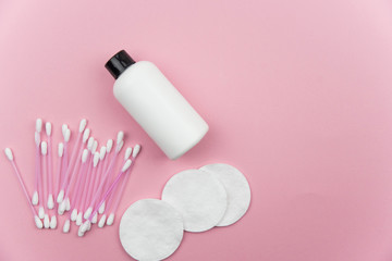 Makeup removal, hygiene, spa and beauty concept. Flat lay with copy space for text. Cotton cosmetic make up removers tampons. Cotton pads, swabs, ear sticks and tonic on trendy pink coral background.