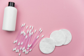 Obraz na płótnie Canvas Makeup removal, hygiene, spa and beauty concept. Flat lay with copy space for text. Cotton cosmetic make up removers tampons. Cotton pads, swabs, ear sticks and tonic on trendy pink coral background.