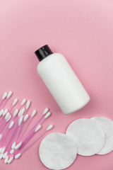 Obraz na płótnie Canvas Makeup removal, hygiene, spa and beauty concept. Flat lay with copy space for text. Cotton cosmetic make up removers tampons. Cotton pads, swabs, ear sticks and tonic on trendy pink coral background.
