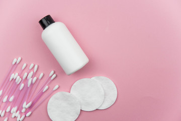 Makeup removal, hygiene, spa and beauty concept. Flat lay with copy space for text. Cotton cosmetic make up removers tampons. Cotton pads, swabs, ear sticks and tonic on trendy pink coral background.