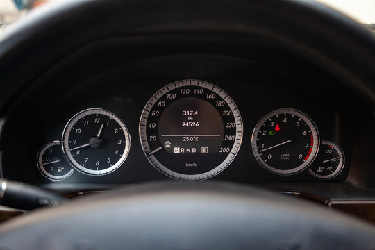 Car dashboard with speedometer, tachometer, clock, fuel tank gauge, oil temperature and display with on-board computer and black odometer with white arrows and divisions. Auto service industry.