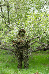 Fototapeta premium Camouflaged sniper in the forest