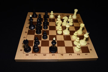 Wooden chess board under black pieces as a skill concept