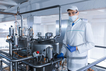 man in a white robe and a cap make an inspection of the production line