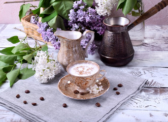 Freshly brewed coffee with a milky foam topped with cinnamon in a brown cup