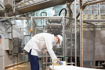 Naklejka na ściany i meble man in a white robe and a cap make an inspection of the production line