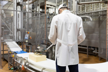 Obraz na płótnie Canvas man in a white robe and a cap make an inspection of the production line