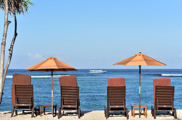 Chairs and sun umbrellas on a white sandy  beach in Gili Meno Island, Lombok, Indonesia