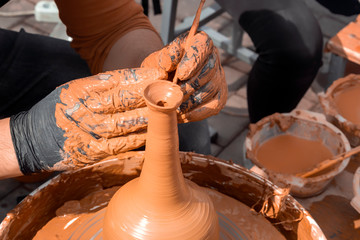 Street potter makes a vase of clay on a potter's wheel. Close-up