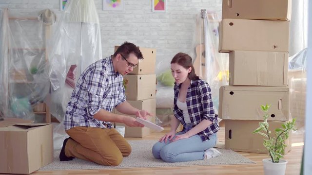 tired and frustrated couple middle-aged man and woman arguing in the middle of moving boxes