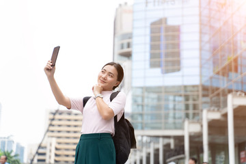 Happy asian woman taking a selfie in the city