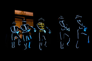 People in glowing costumes dancing in the dark