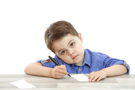 little boy sits and draws writes on an isolated background