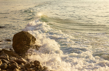 foaming wave breaking into the distance from a rocky shore