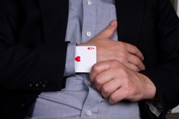 Card ace of hearts in the black sleeve of the suit