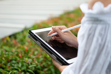 Women read or analyze reports on tablet computers. In the midst of nature