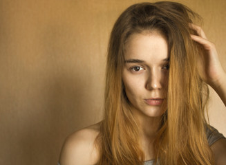Naklejka premium A beautiful girl looks at the camera with a charming mysterious look
