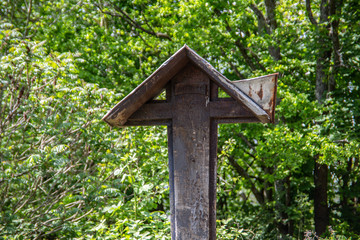 hölzernes großes Kirchenkreuz im bewaldeten Gelände