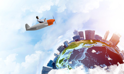 Man in aviator hat with goggles driving plane