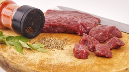 Fresh raw beef meat on cutting board with herbs and spices