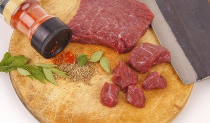 Fresh raw beef meat on cutting board with herbs and spices