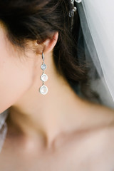 Face of a young woman with big earrings close up