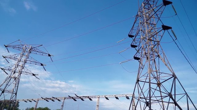 Electricity pylons. Moving along two row of pylons. electric high voltage pylon against beautiful sky. energy efficiency conception. loopable animation