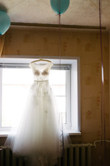 White wedding dress hanging in the bedroom. White bride dress