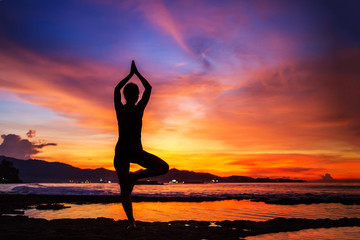 Caucasian woman practicing yoga at seashore