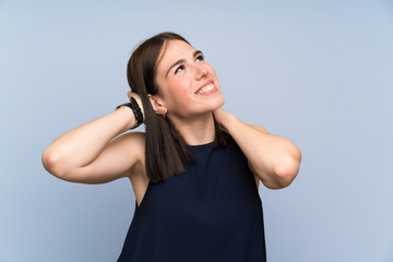 Young woman over isolated blue wall laughing