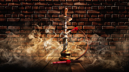 Hookah smoking on the background of an old brick wall, illuminated by a searchlight