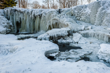 Fototapeta na wymiar Famous waterfall in Estonia. Keila-Joa Schloss Fall. Partly frozen waterfall by winter. Estonia.