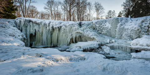 Famous waterfall in Estonia. Keila-Joa Schloss Fall. Partly frozen waterfall by winter. Panoramic. Estonia.