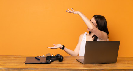 Business woman in a office holding copyspace to insert an ad