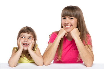 Mom and her little daughter, sitting at the table, laughing, emotions and gestures, happy girls, on a white background