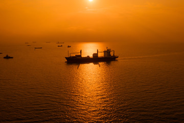 silhouette logistics shipping cargo open sea and over the sunset background
