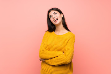 Obraz premium Teenager girl over isolated pink wall looking up while smiling