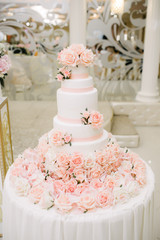 Big white wedding cake with fruit is on the table