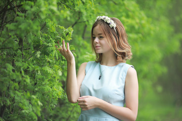 Girl in blue dress in green park