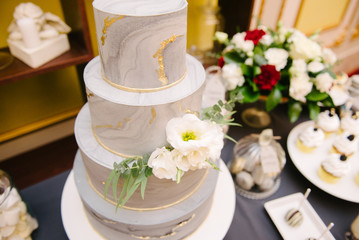 Big white wedding cake with fruit is on the table