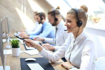 Female customer support operator with headset and smiling.