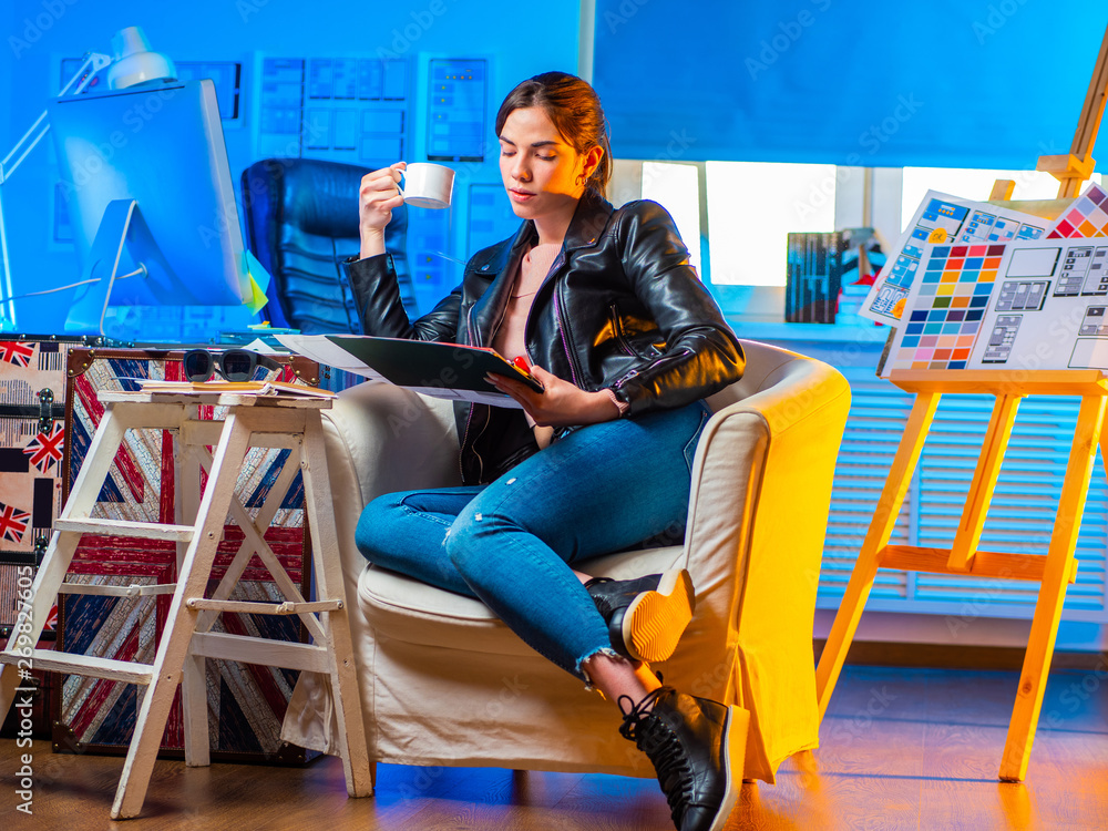 Poster supernumerary designer. freelance girl designer looks at the drawn layout of the future mobile appli