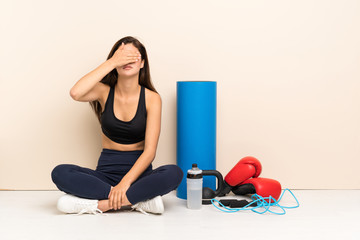 Teenager sport girl sitting on the floor covering eyes by hands. Do not want to see something