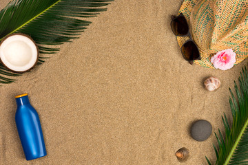 Fototapeta na wymiar Space for text, beach theme on sand background. Hat, sunglasses, sunscreen, coconuts on sand background. Top view.