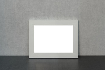 large empty white photo frame horizontally stands on a shelf in the living room, minimalism style in home interior, mock-up